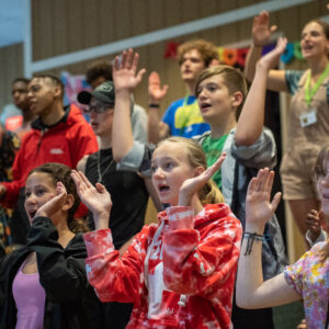 Campers sing and do motions during summer Camp worship.